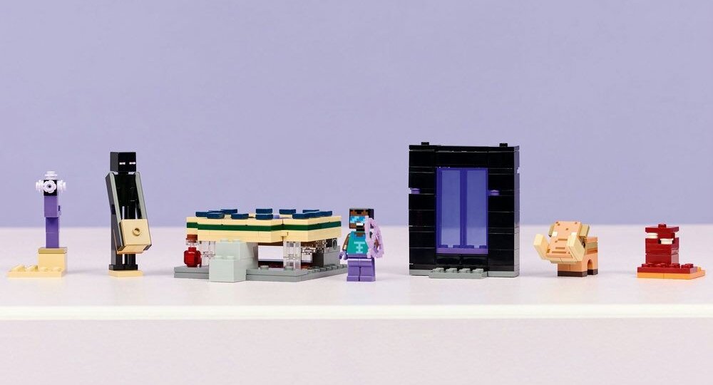 Na białej powierzchni ustawione są różne figurki i konstrukcje z klocków LEGO, w tym postacie i portal. Tło jest jednolite, w kolorze jasnofioletowym.