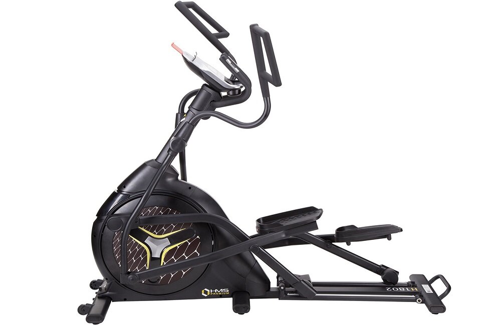 Na obrazie widoczny jest czarny orbitrek magnetyczny z logo \'HMS Fitness\' na obudowie. Urządzenie posiada uchwyty i pedały, a na obudowie widać wzór w kształcie litery Y.