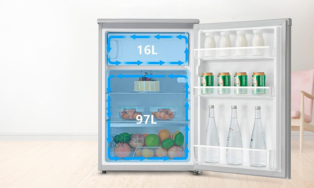 Otwarta biała lodówka z widocznymi dwoma komorami o pojemności 16L i 97L, wypełniona różnymi produktami spożywczymi. Na drzwiach znajdują się półki z butelkami i puszkami.