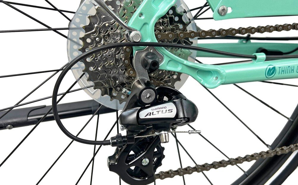 Zdjęcie przedstawia tylną część roweru z widocznym mechanizmem przerzutki Shimano Altus oraz kasetą zębatek. Rama roweru jest w kolorze akwamaryny.