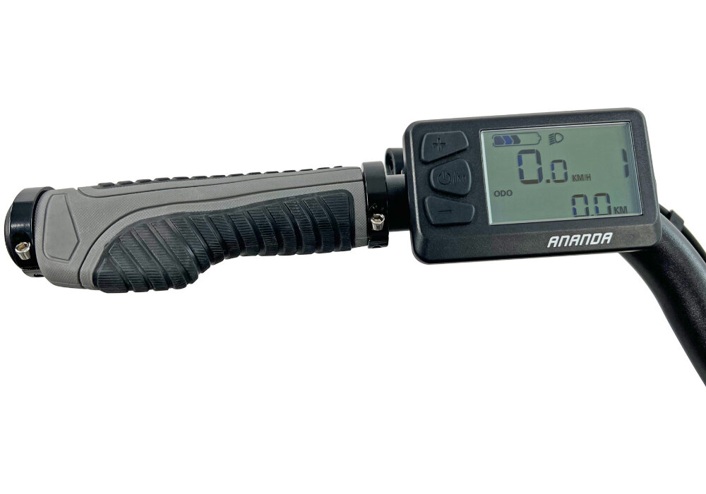 Obraz przedstawia kierownicę roweru z wyświetlaczem elektronicznym. Na ekranie widoczny jest napis \'ANANDA\' oraz wskaźniki prędkości i dystansu w kilometrach.