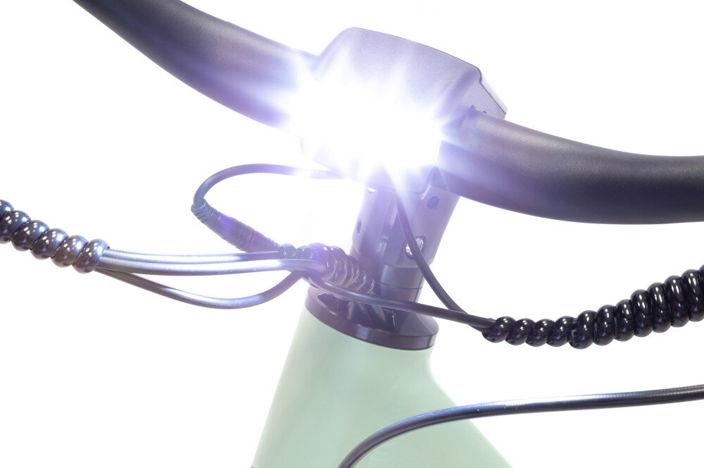Rower elektryczny PLATUM City 7S M19.5 27.5 cala Zielony białe tło zbliżenie na przednią lampę lampa jest włączona przedni reflektor LED tylne światło LED z funkcją sygnalizacji hamowania zwiększa swoją jasność podczas hamowania odblaskowe paski na oponach komfort poruszania się po zmroku