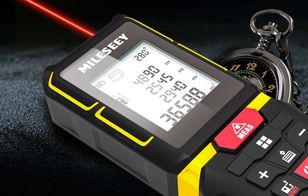 Dalmierz laserowy MILESEEY G7 100m, Urządzenie, laser, zegarek, wiązka, Dalmierz laserowy Mileseey emitujący czerwoną wiązkę światła, leżący obok klasycznego zegarka kieszonkowego.