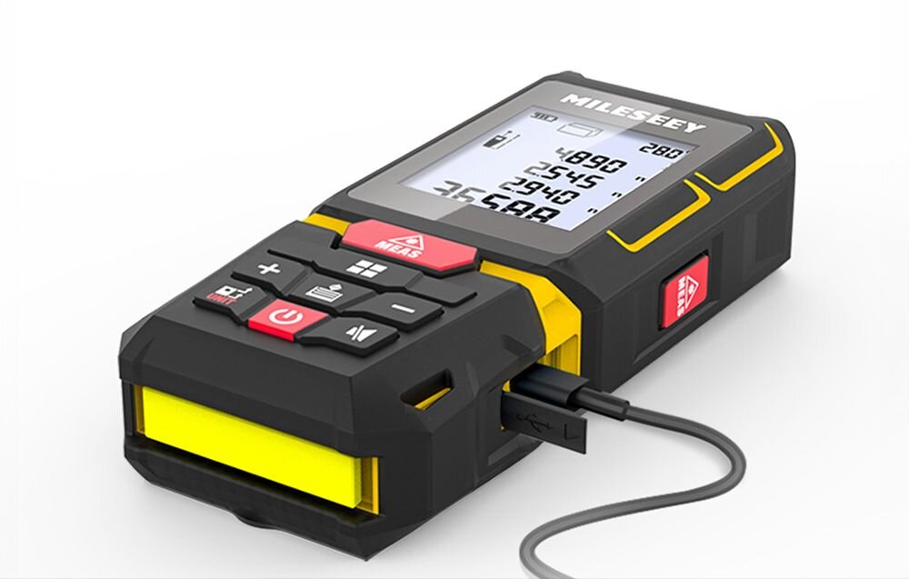 Dalmierz laserowy MILESEEY G7 100m, Dalmierz, ładowanie, kabel, USB, Dalmierz laserowy leżący na jasnym tle, z podłączonym przewodem USB do ładowania w bocznej części obudowy.