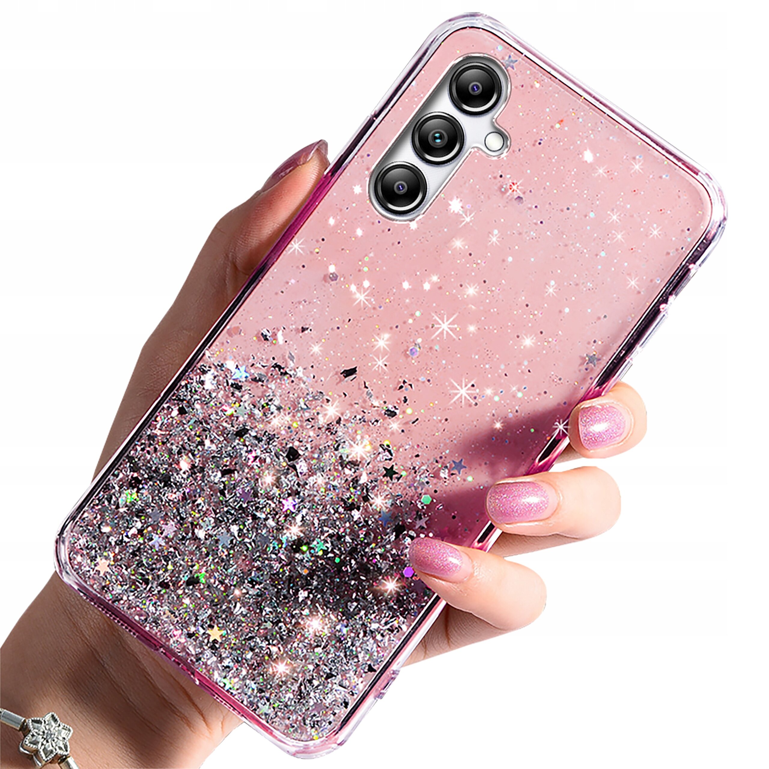 Różowe etui na telefon z brokatowym wzorem i trzema widocznymi aparatami fotograficznymi, trzymane w dłoni z pomalowanymi paznokciami.