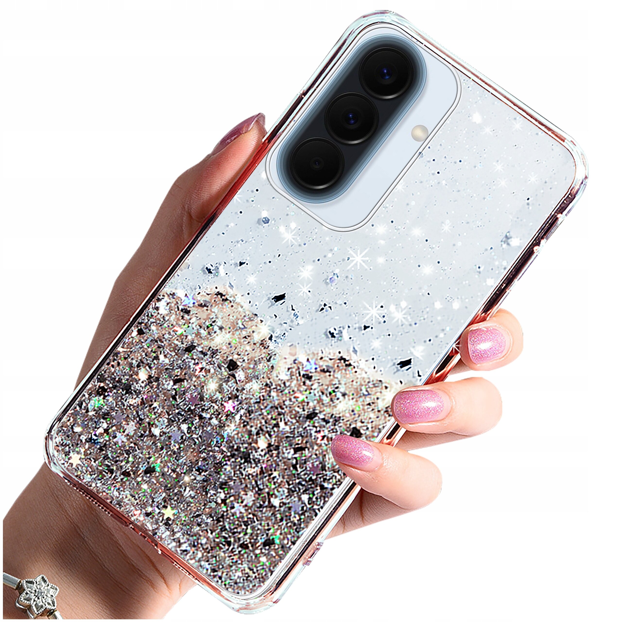 Osoba trzyma telefon w etui z brokatowym wzorem, które połyskuje w świetle. Etui ma przezroczyste krawędzie i wycięcie na aparat z trzema obiektywami.