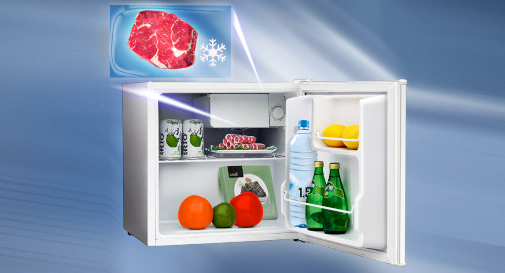 Otwarta biała lodówka z widocznymi produktami spożywczymi, takimi jak butelki, owoce i puszki. W górnym rogu obrazek przedstawiający kawałek mięsa z symbolem płatka śniegu.
