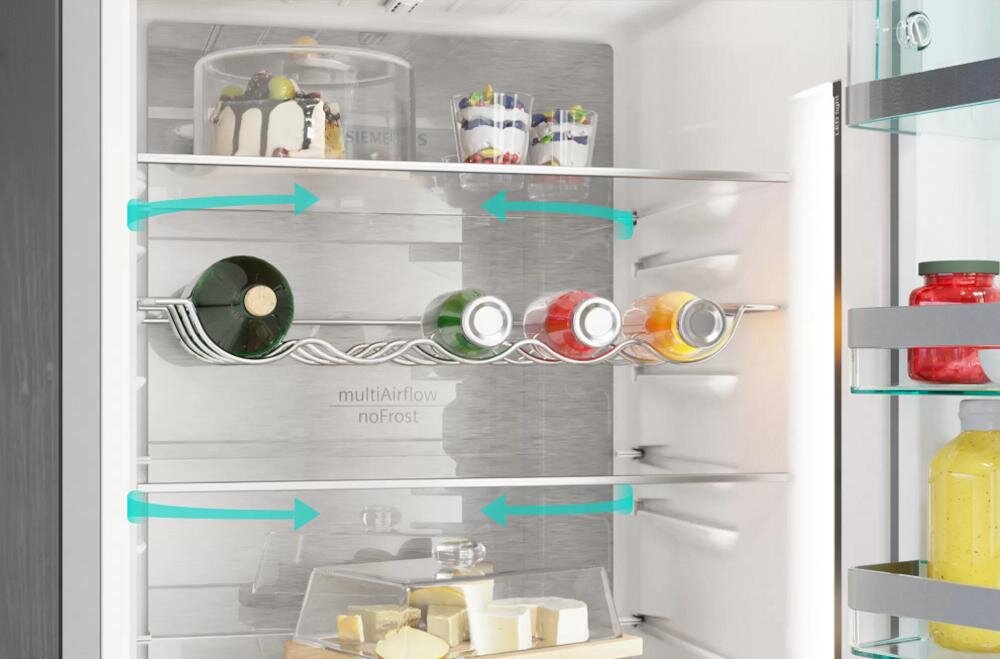 Wnętrze lodówki z widocznymi półkami, na których znajdują się ciasta, butelki i słoiki. Na tylnej ściance widoczny jest napis \'multiAirflow noFrost\'.