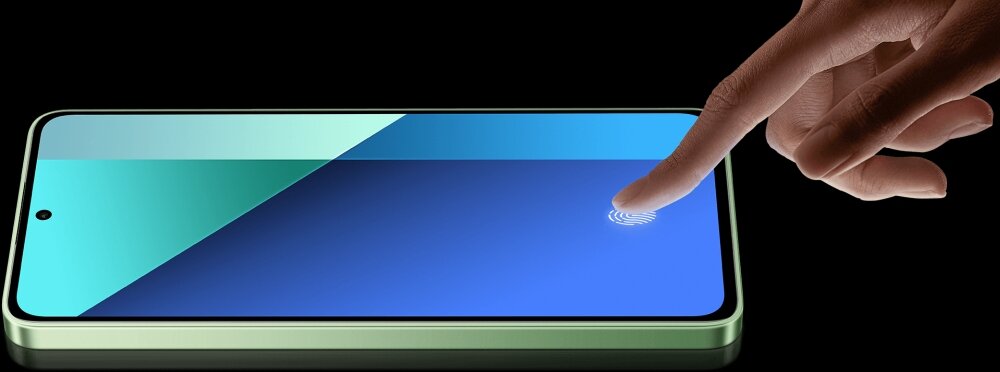 Na obrazie widoczny jest zielony smartfon z dużym ekranem, na którym widać odcisk palca. Palec zbliża się do ekranu, sugerując funkcję dotykową lub odblokowywania.