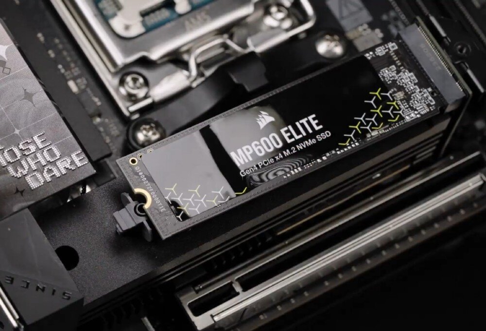 Na obrazie widoczny jest dysk SSD z napisem \'MP600 ELITE Gen4 PCIe x4 M.2 NVMe SSD\' zamontowany na płycie głównej. Obok znajduje się fragment tekstu \'THOSE WHO DARE\'.