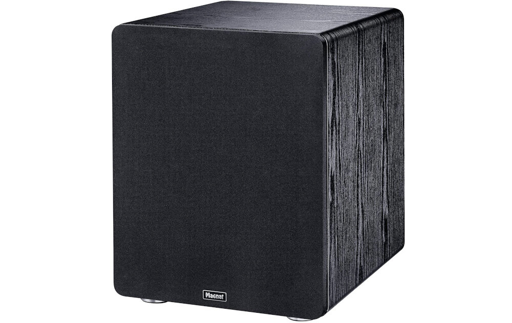 Czarny subwoofer o prostokątnym kształcie z widocznym logo \'Magnat\' na dole przedniego panelu. Obudowa wykonana z MDF z wyraźną teksturą drewna.