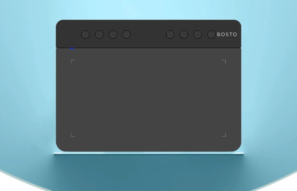 Tablet graficzny BOSTO T1060K Tablet graficzny widziany od góry na jasnoniebieskim tle, z widocznym panelem roboczym, diodą LED i ośmioma okrągłymi przyciskami w górnej części, opis