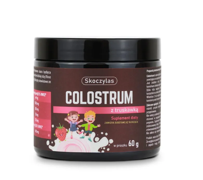 Opakowanie produktu Skoczylas Colostrum z Truskawką 60g z widocznym logo i grafiką przedstawiającą dzieci oraz truskawkę. Na etykiecie znajduje się napis: \'Suplement diety zawiera substancję słodzącą\'.