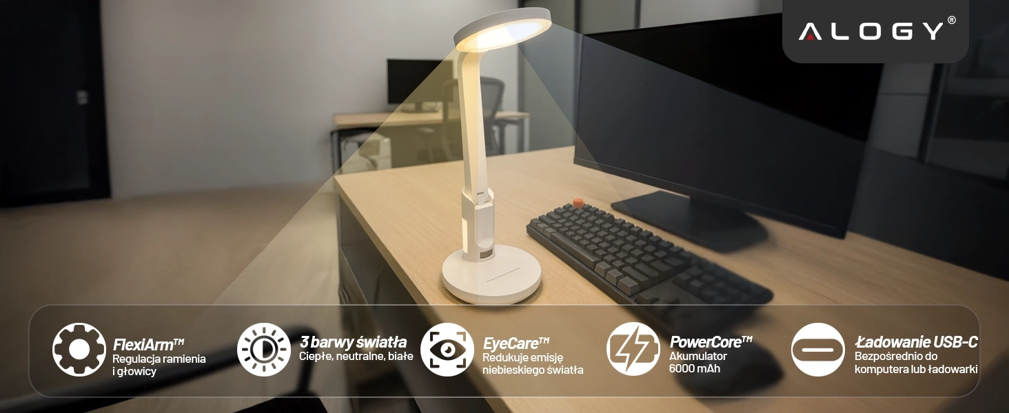Na biurku znajduje się biała lampka biurkowa z regulowanym ramieniem, obok monitora i klawiatury. Na dole obrazu widoczne są ikony z tekstem: \'FlexiArm™ Regulacja ramienia i głowicy\', \'3 barwy światła Ciepłe, neutralne, białe\', \'EyeCare™ Redukuje emisję niebieskiego światła\', \'PowerCore™ Akumulator 6000 mAh\', \'Ładowanie USB-C Bezpośrednio do komputera lub ładowarki\'.