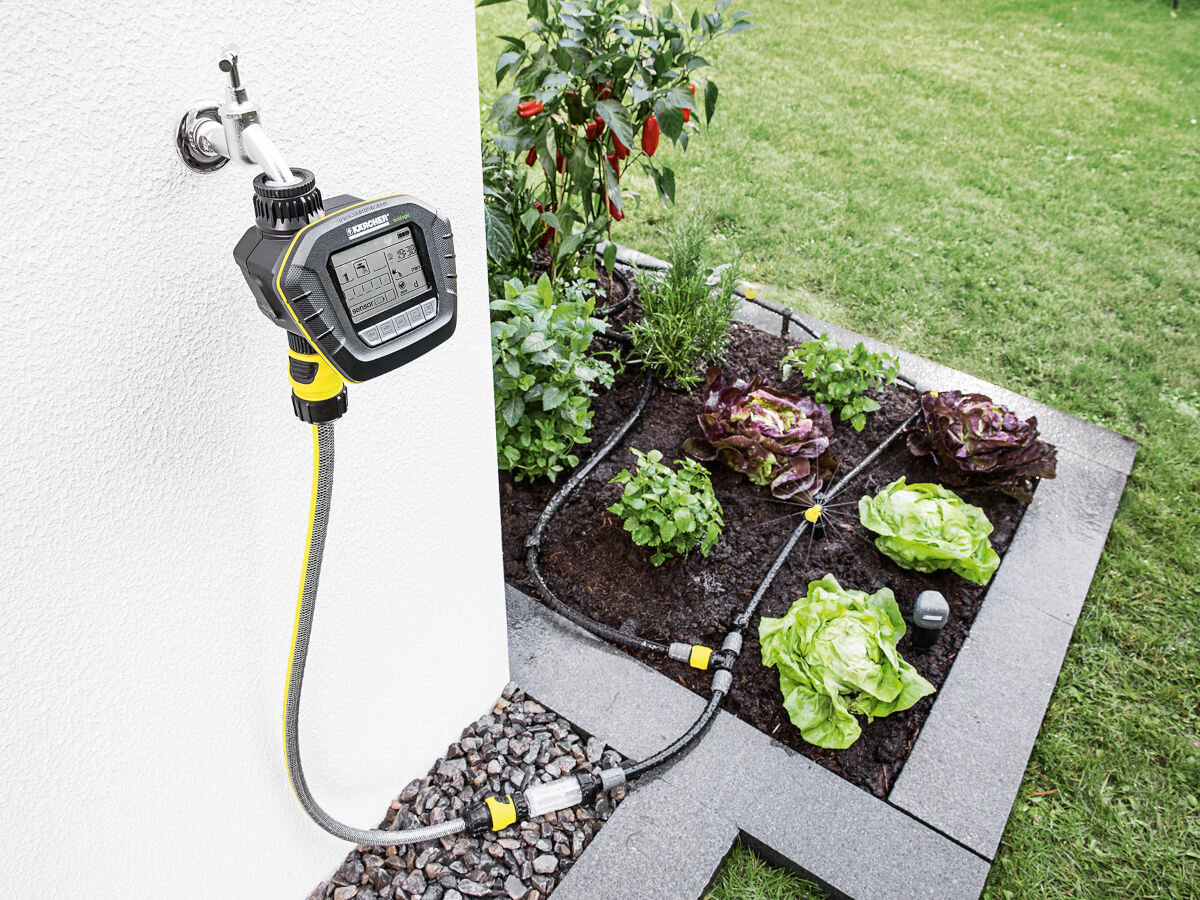 Zestaw do nawadniania KARCHER Rain System 2.645-238.0, regulacja, ogród, zwiększyć, woda, do ściany domu zamontowany regulator wody, obok wąż dozuje wodę do roślin