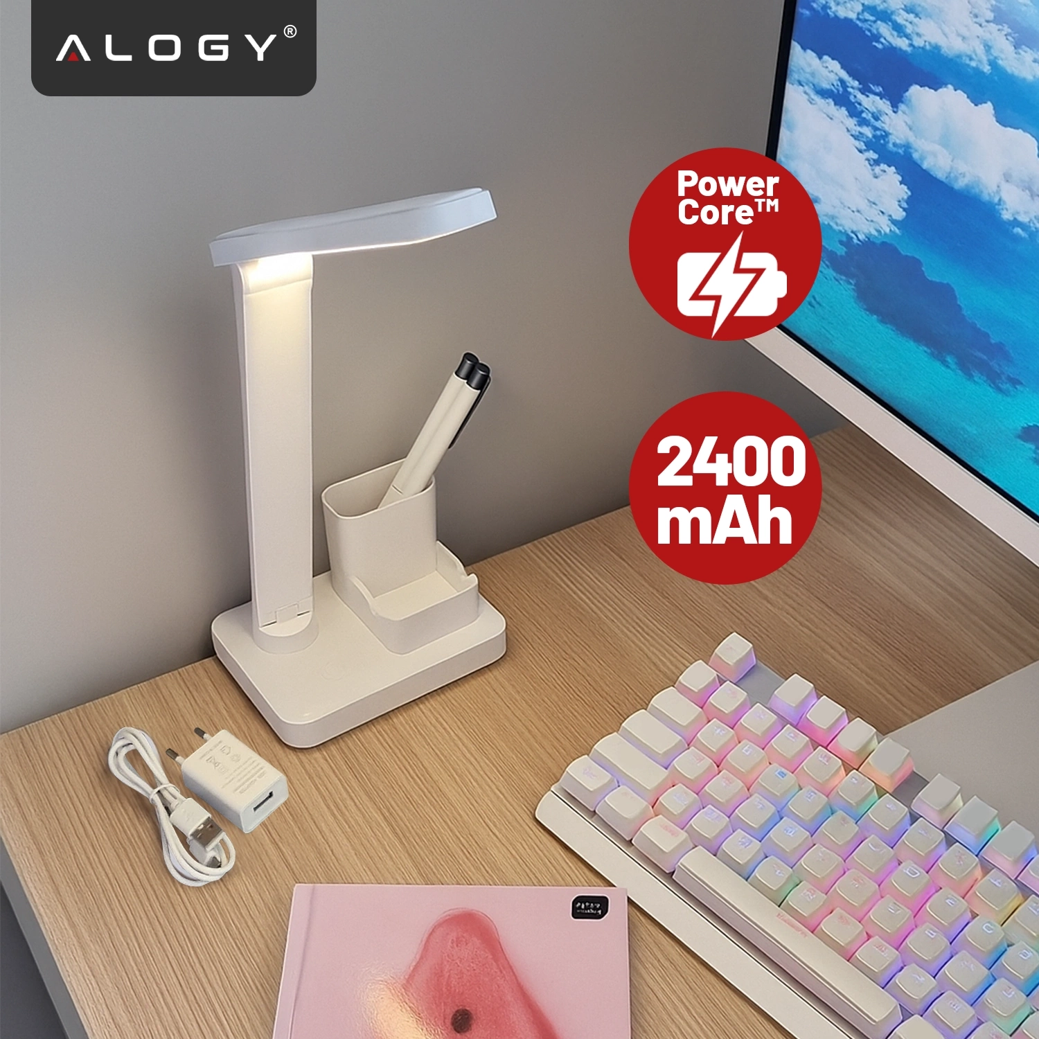 Na biurku znajduje się biała lampka biurkowa LED z organizerem, obok której leży kabel USB i ładowarka. Na obrazie widoczne są napisy: \'Alogy\', \'Power Core™\', \'2400 mAh\'.