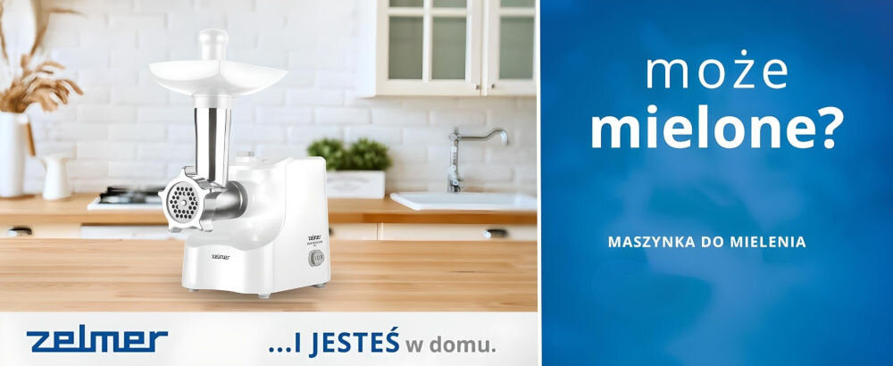 Na blacie kuchennym stoi biała maszynka do mięsa z metalowym elementem mielącym. Obok na niebieskim tle widnieje napis: \'może mielone? MASZYNKA DO MIELENIA\'.