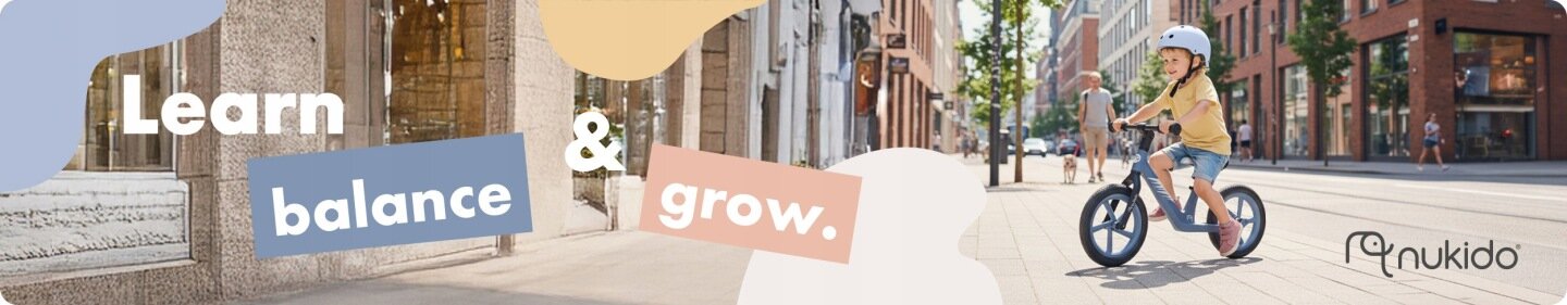 Dziecko w kasku jedzie na rowerku biegowym po miejskiej ulicy. Na obrazie widoczny jest tekst: \'Learn balance & grow.\' oraz logo \'nukido\'.