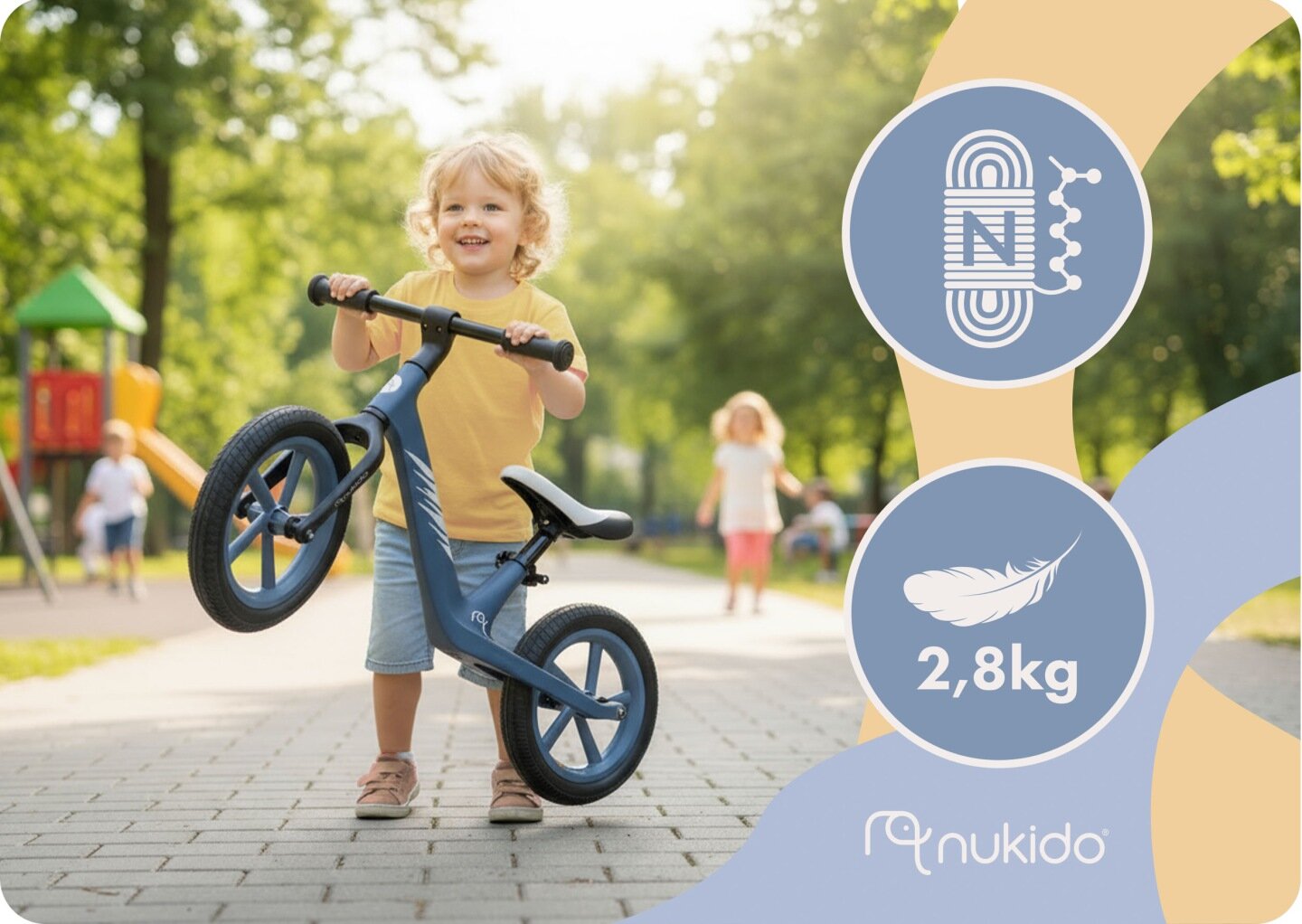 Dziecko trzyma rowerek biegowy na ścieżce w parku, w tle widać plac zabaw. Na grafice obok znajduje się logo \'nukido\' oraz symbol piórka z napisem \'2,8kg\'.