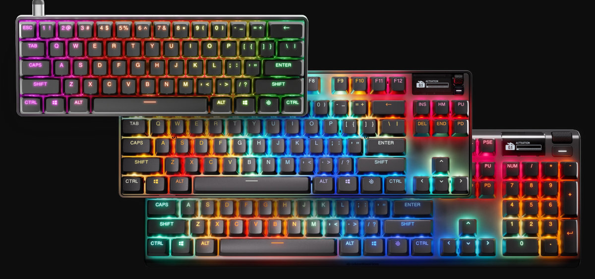 Na obrazie widoczne są trzy klawiatury z podświetleniem RGB, każda z różnorodnymi kolorami na klawiszach. Klawiatury mają różne układy klawiszy, a na jednej z nich widoczne jest logo producenta i napis \'media expert\'.