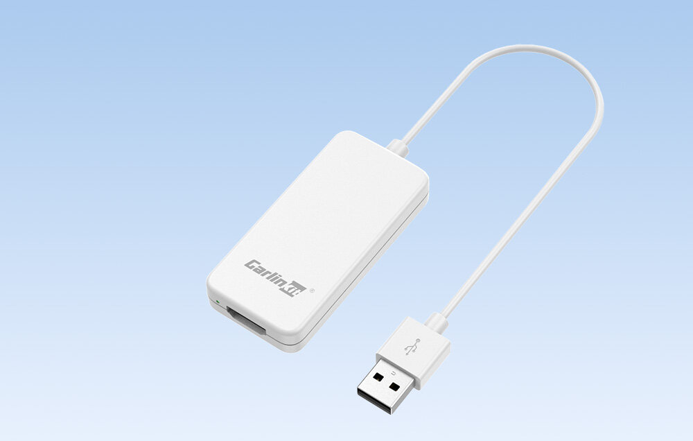 Na obrazie widoczny jest biały adapter z logo \'Carlinkit\' oraz podłączonym kablem USB. Tło jest jasnoniebieskie.