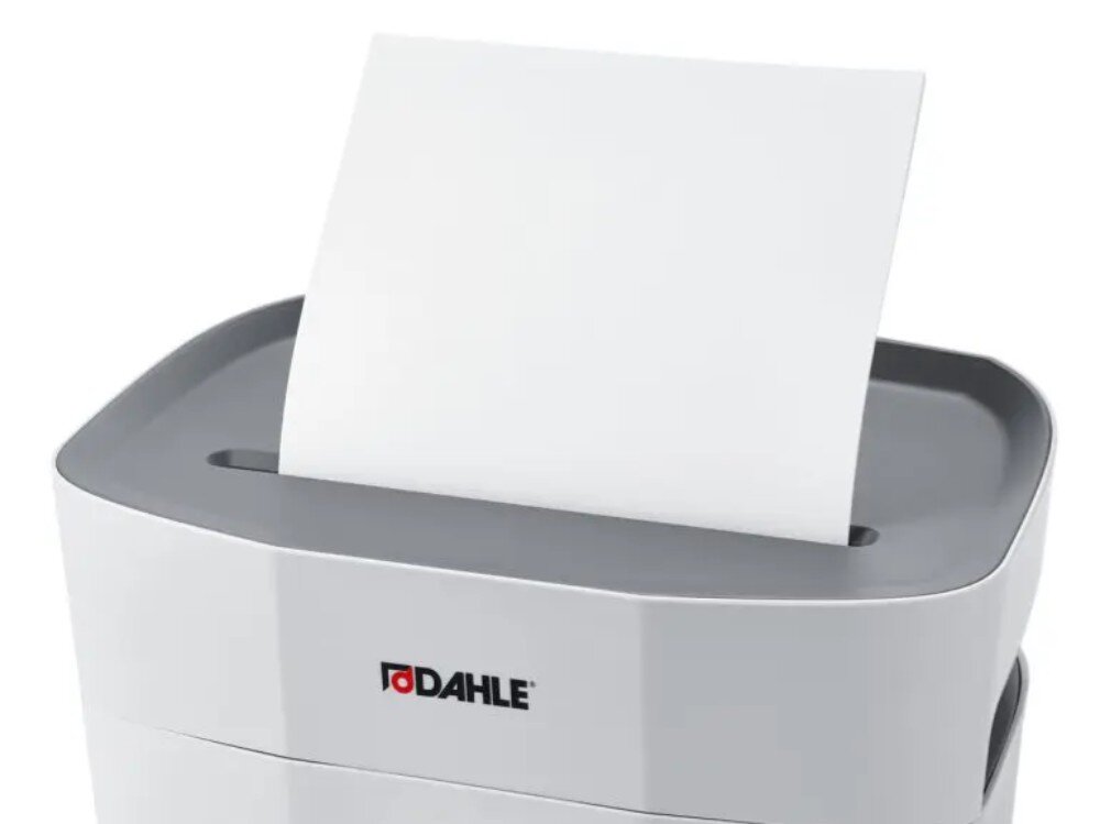 Niszczarka DAHLE PaperSAFE Zbliżenie na górną część niszczarki z pionowo włożonym arkuszem białego papieru w szczelinę tnącą