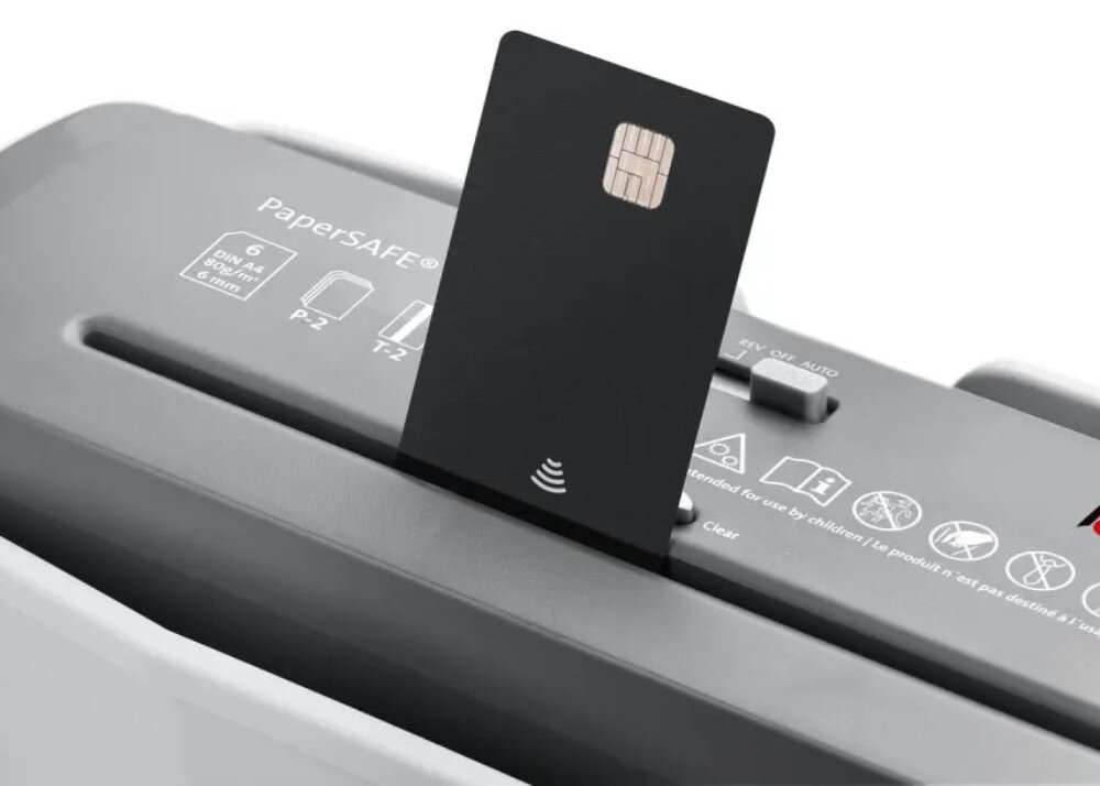 Na obrazie widoczna jest niszczarka z kartą włożoną do szczeliny. Na urządzeniu znajduje się tekst: \'PaperSAFE\', \'6 DIN A4 1x1 cm\', \'P-2\', \'T-2\'.
