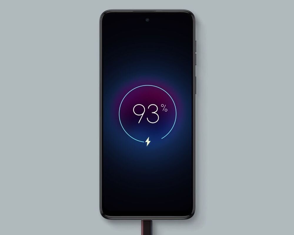 Smartfon z wyświetlaczem pokazującym ikonę ładowania i napis \'93%\'. Urządzenie jest podłączone do ładowarki.