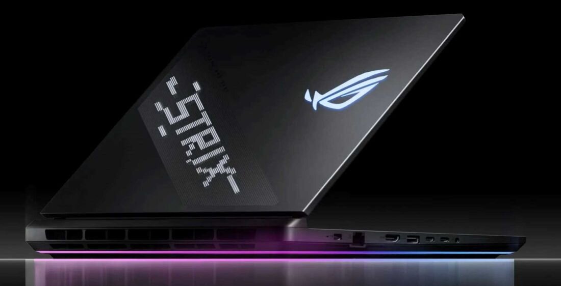 Laptop z podświetlanym logo producenta i napisem \'STRIX\' na obudowie. Widoczna jest także kolorowa linia świetlna na dolnej krawędzi urządzenia.