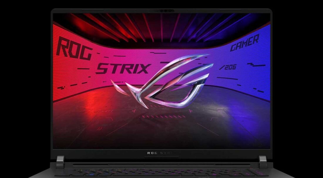 Laptop z wyświetlaczem pokazującym kolorowe tło z napisem \'ROG STRIX GAMER\' oraz dużym logo w centrum. Klawiatura laptopa jest podświetlona na różne kolory.