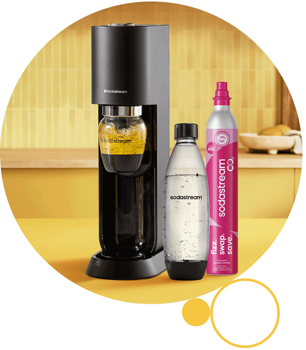Na obrazie znajduje się czarny saturator z logo \'sodastream\', obok niego przezroczysta butelka z wodą gazowaną oraz różowy nabój CO2 z napisem \'fizz. swap. save.\'.