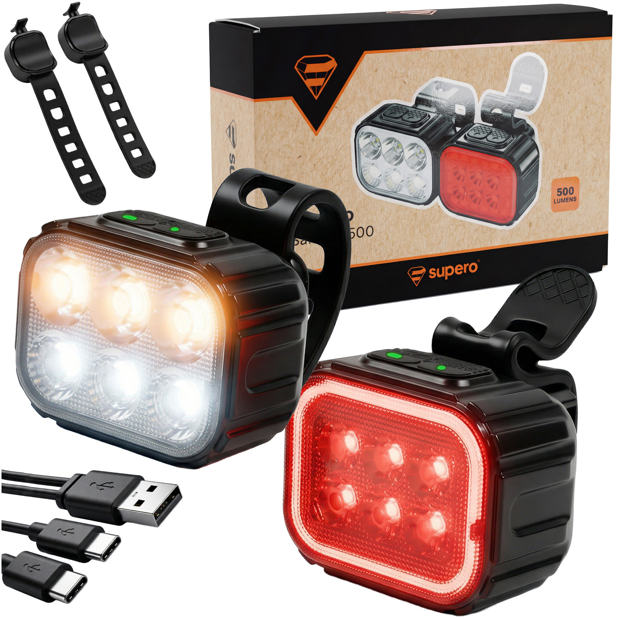 Na zdjęciu znajduje się zestaw lampki rowerowej przedniej i tylnej z mocnymi diodami LED, obok opakowania z logo \'supero\' i napisem \'500 lumens\'. W zestawie widoczne są również dwa kable USB-C oraz dwa paski mocujące.