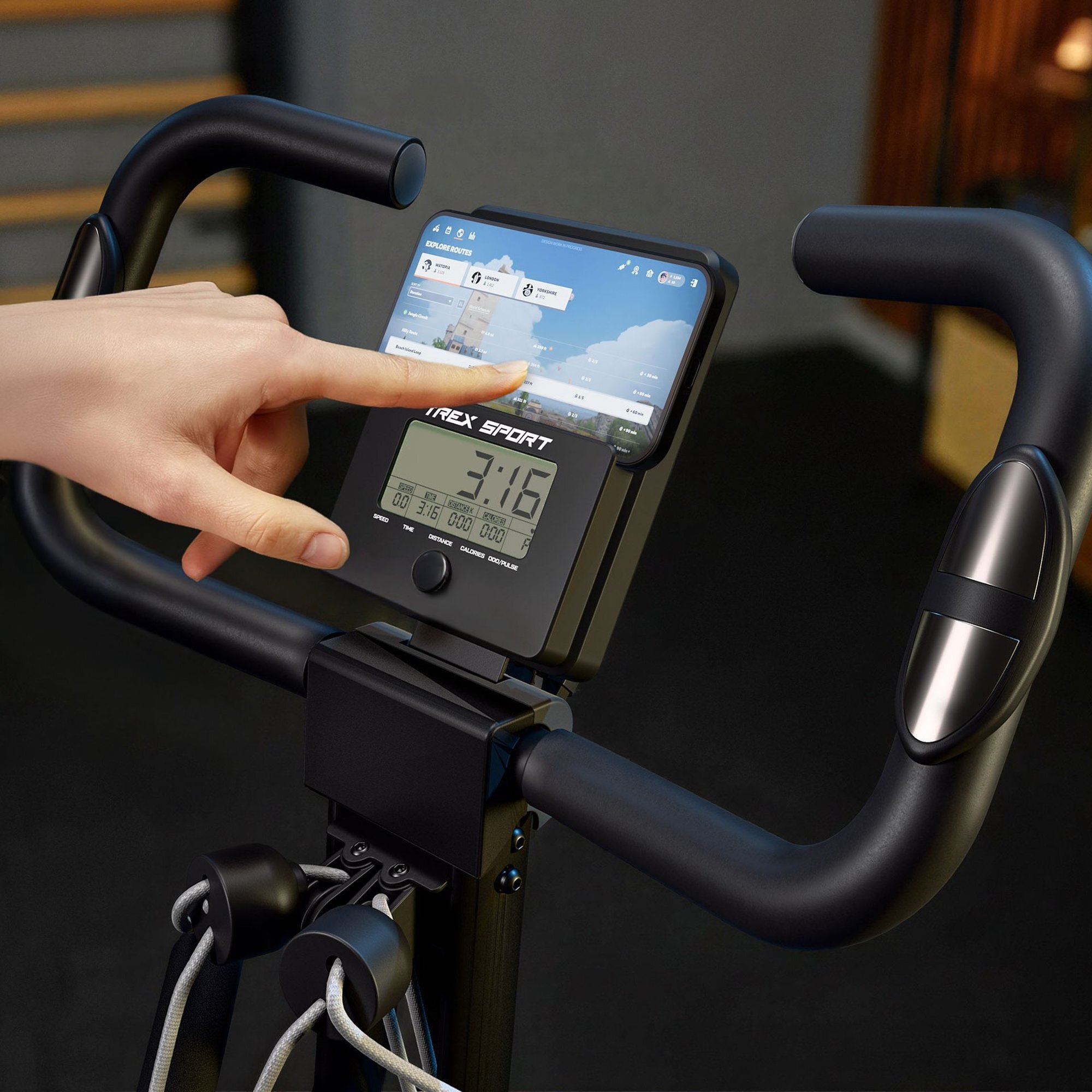 Osoba dotyka ekranu dotykowego na rowerze stacjonarnym, na którym widoczny jest napis \'IREX SPORT\' oraz wyświetlacz z czasem \'3:16\'. Kierownica roweru jest czarna, a w tle widać rozmyte elementy wnętrza.