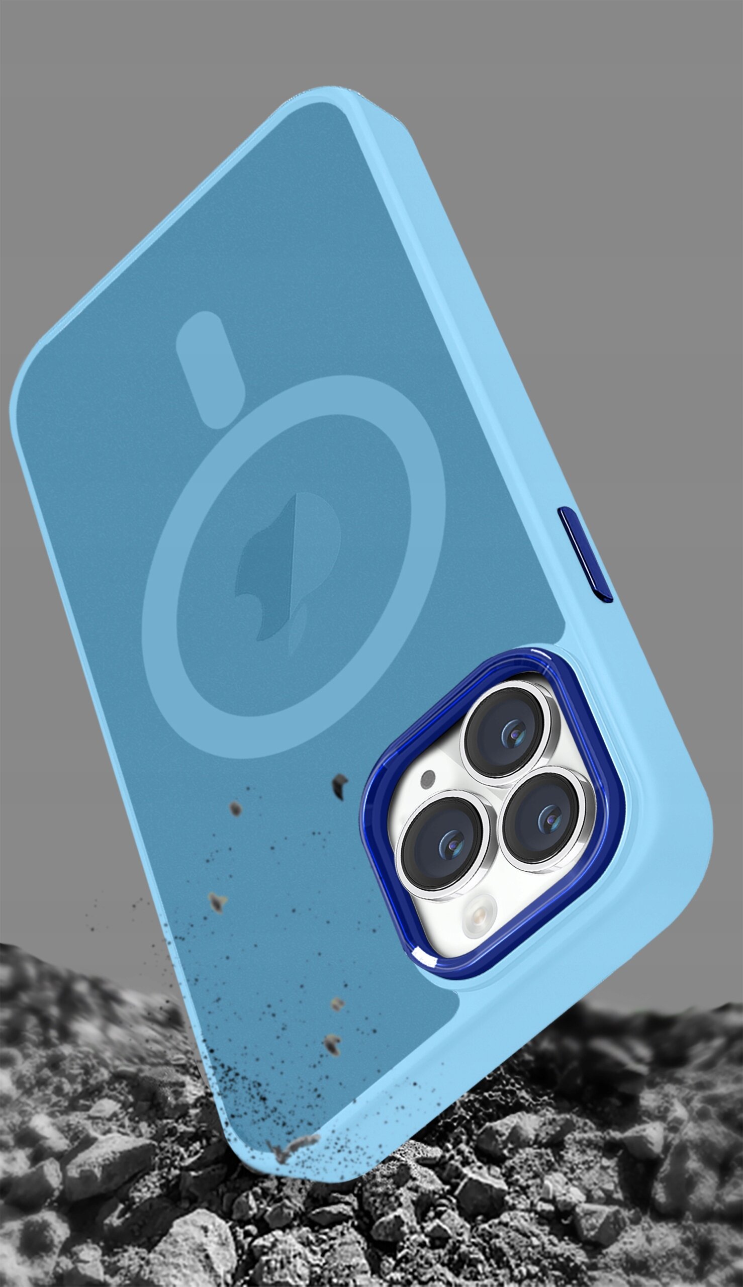 Niebieskie etui na telefon z trzema widocznymi obiektywami aparatu, leży na tle przypominającym kamienie. Etui ma okrągły wzór sugerujący kompatybilność z MagSafe.