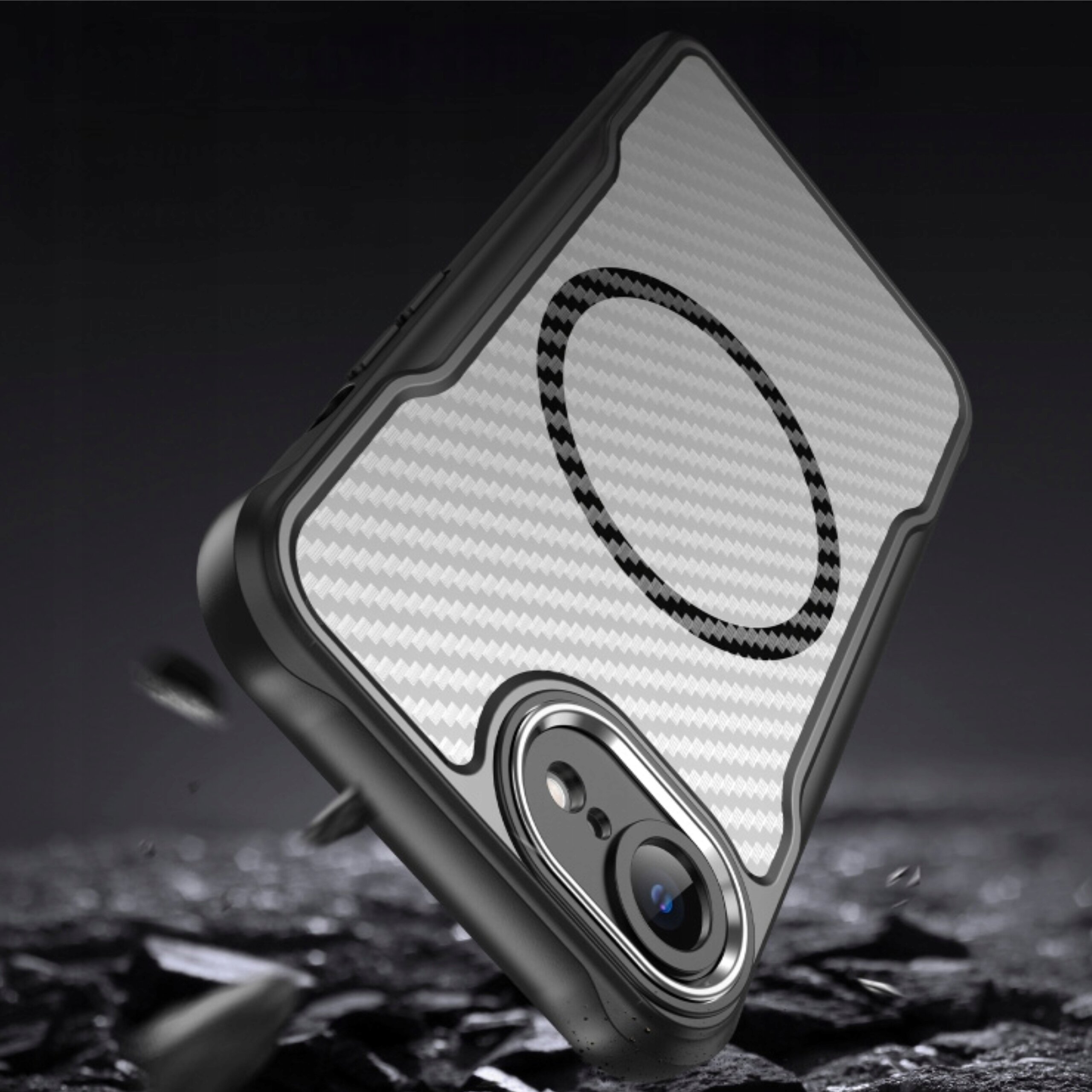 Obraz przedstawia czarne, matowe etui pancerne z wzmacnianymi krawędziami, przeznaczone do iPhone\'a. Na etui widoczny jest okrągły wzór, a w tle znajdują się rozmyte elementy przypominające kamienie.