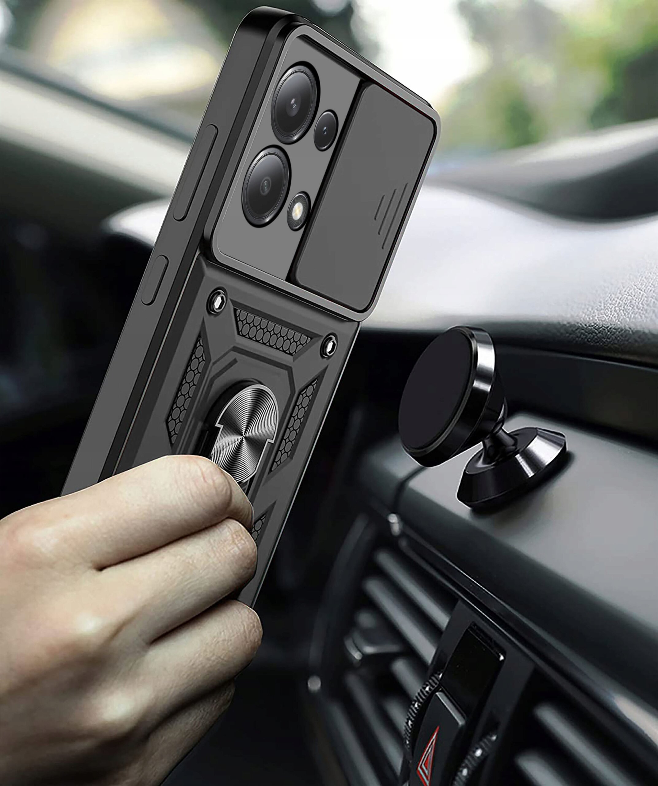 Etui do Xiaomi Redmi Note 13 |13 4G Pancerne Slide Ring Case z widocznym pierścieniem na tylnej części, trzymane w ręce w samochodzie obok uchwytu magnetycznego.