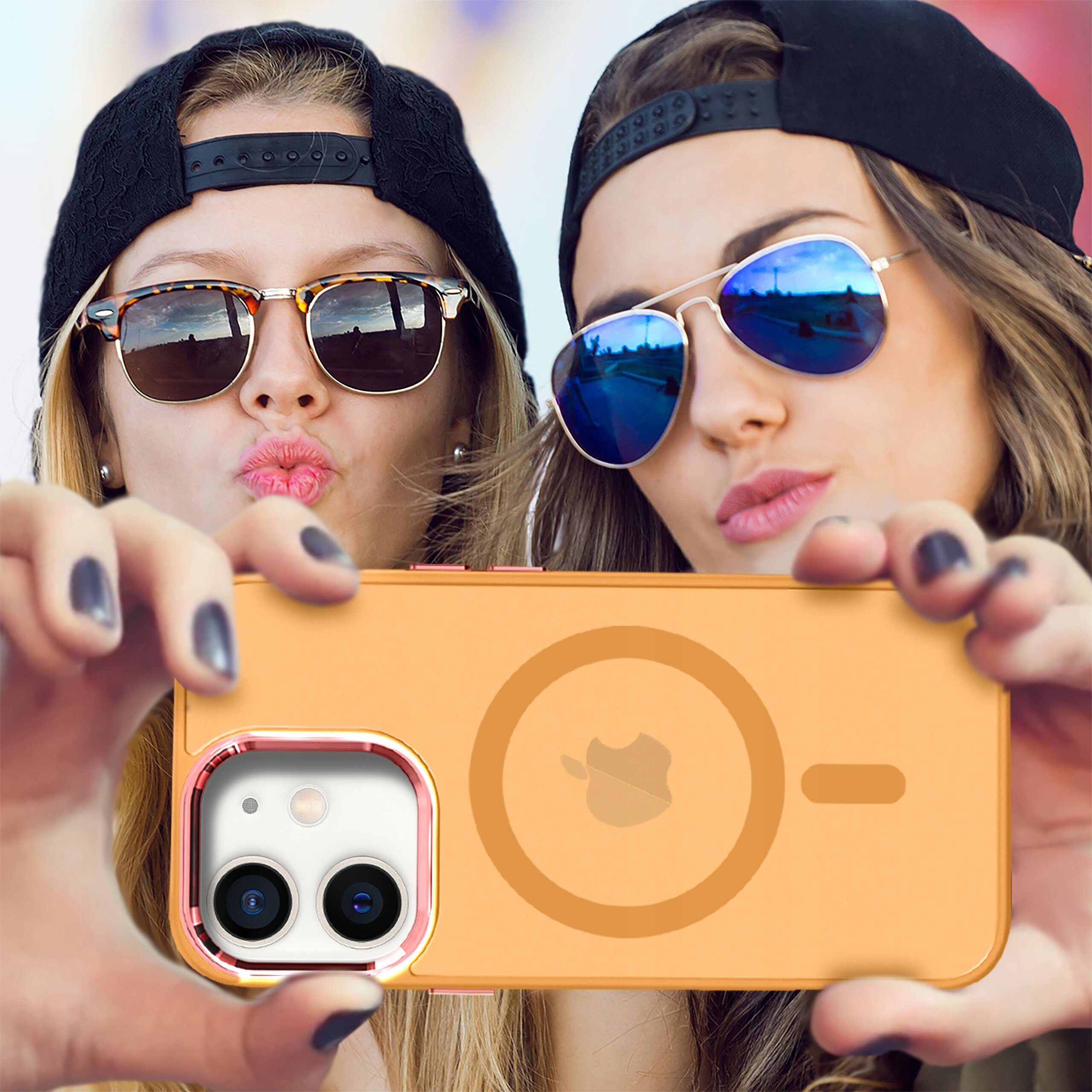 Dwie osoby w okularach przeciwsłonecznych robią sobie zdjęcie telefonem w pomarańczowym etui z widocznym logo producenta. Etui jest przeznaczone do iPhone 12 | 12 Pro i posiada funkcję MagSafe.