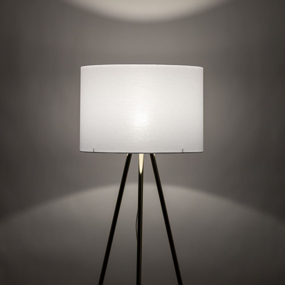 Lampa podłogowa z białym kloszem na trójnogu, emitująca światło na szare tło.