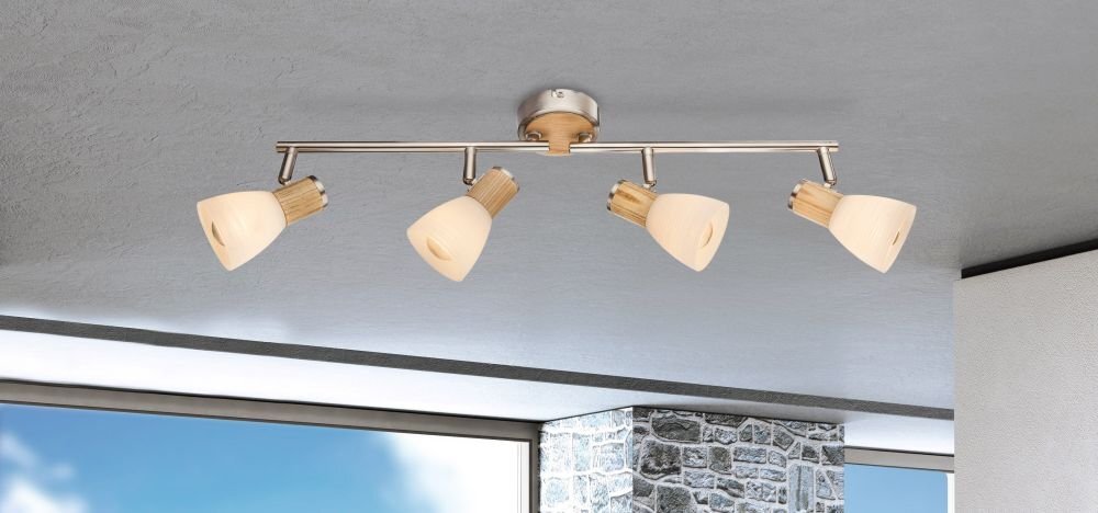 Lampa sufitowa z czterema kloszami w kolorze opalowym, zamontowana na metalowej listwie w pomieszczeniu z widokiem na niebo i kamienną ścianę.