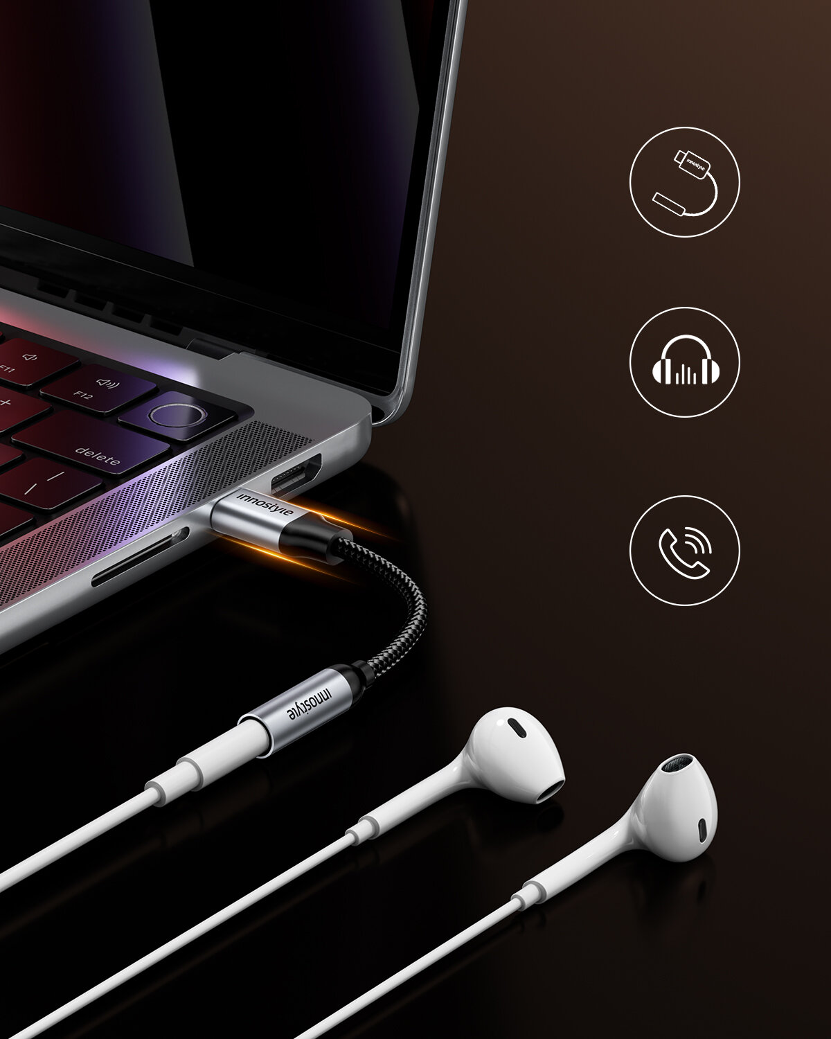 Zdjęcie przedstawia adapter USB-C do mini jack 3,5 mm podłączony do laptopa, z widocznymi słuchawkami i ikonami symbolizującymi funkcje magnetyczne, audio i połączenia. Na adapterze widoczny jest napis \'innostyle\'.
