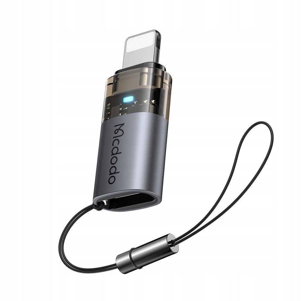 Na obrazie widoczny jest adapter USB-C do Lightning z logo \'Mcdodo\' oraz podświetleniem LED. Adapter posiada szary korpus i jest wyposażony w czarny pasek do zawieszenia.