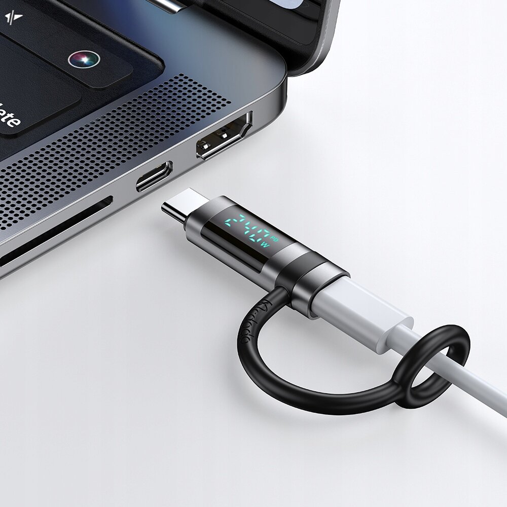 Adapter USB-C z wyświetlaczem podłączony do laptopa, na ekranie widoczny jest tekst \'Mcdodo\'.