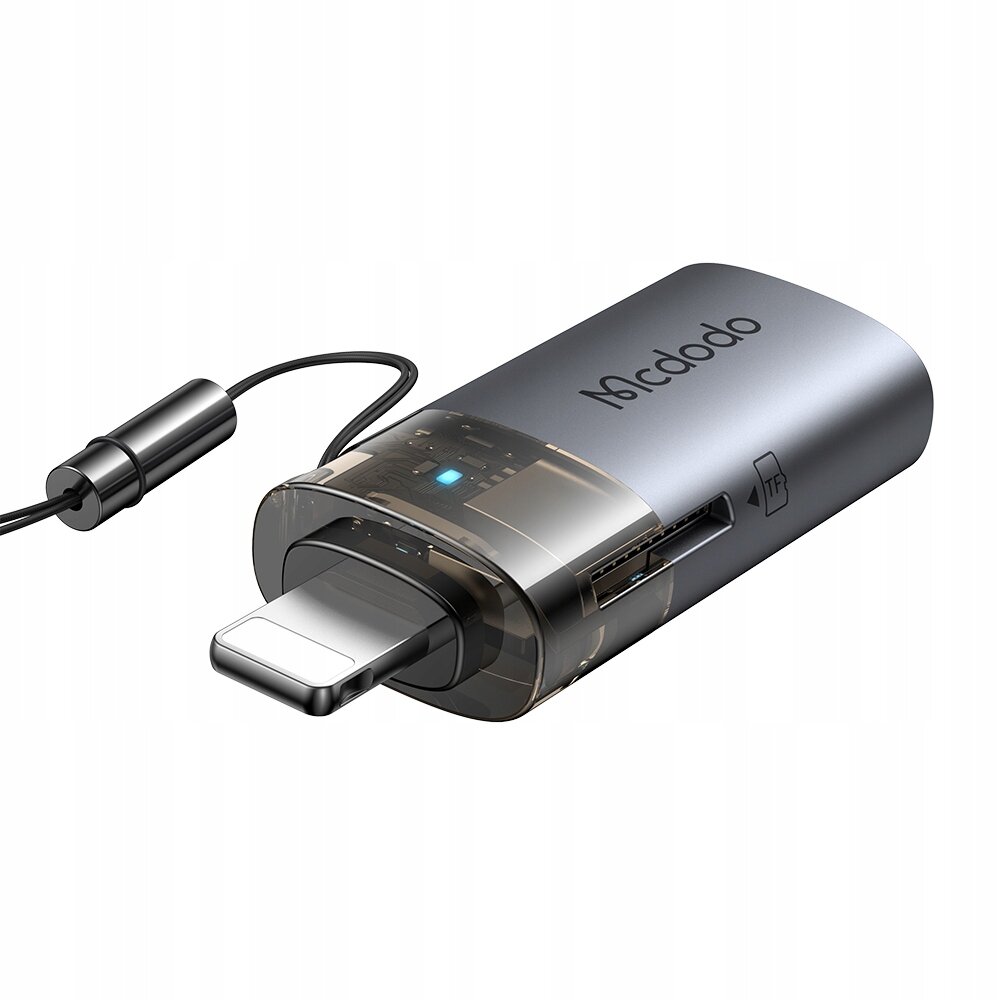 Na obrazie widoczny jest adapter USB-A do Lightning z czytnikiem kart TF, oznaczony logo \'Mcdodo\'. Adapter ma przezroczystą część z widocznym niebieskim wskaźnikiem LED oraz gniazdo na kartę TF.