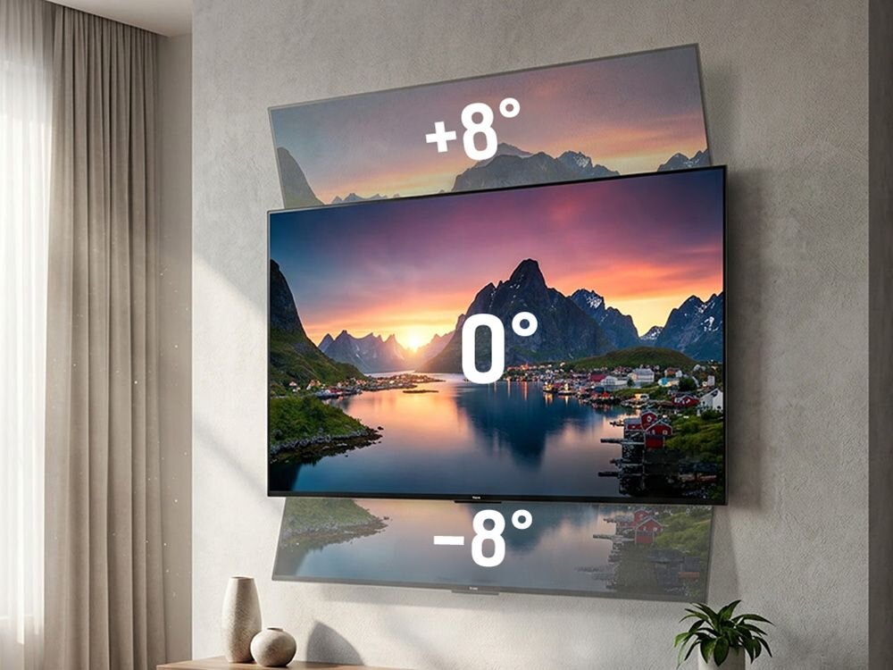 Na ścianie zamontowany jest telewizor z widokiem na górski krajobraz, z oznaczeniami kątów nachylenia: +8°, 0°, -8°. W tle widoczne są zasłony i dekoracje roślinne.