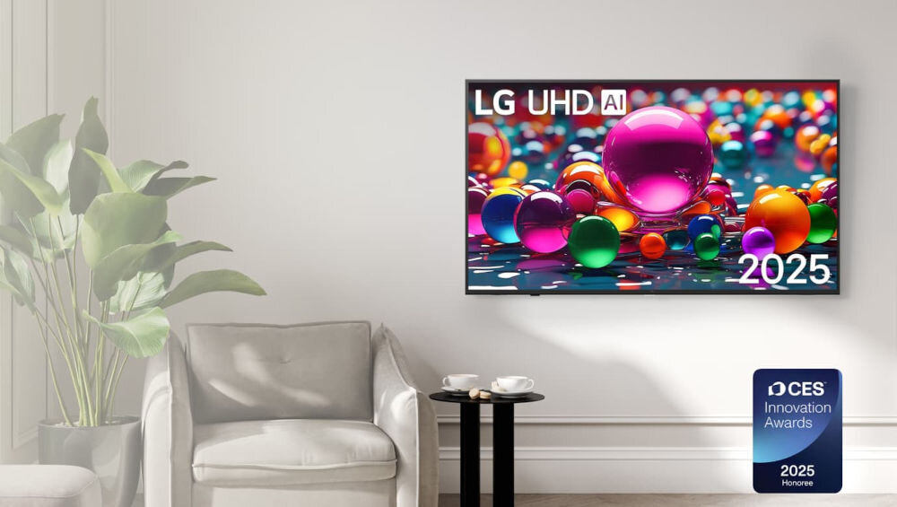 Na ścianie wisi telewizor z kolorowym obrazem przedstawiającym różnobarwne kule, z widocznym napisem \'LG UHD AI\' oraz \'2025\'. Obok telewizora stoi roślina w doniczce i fotel, a na podłodze znajduje się plakietka z napisem \'CES Innovation Awards 2025 Honoree\'.