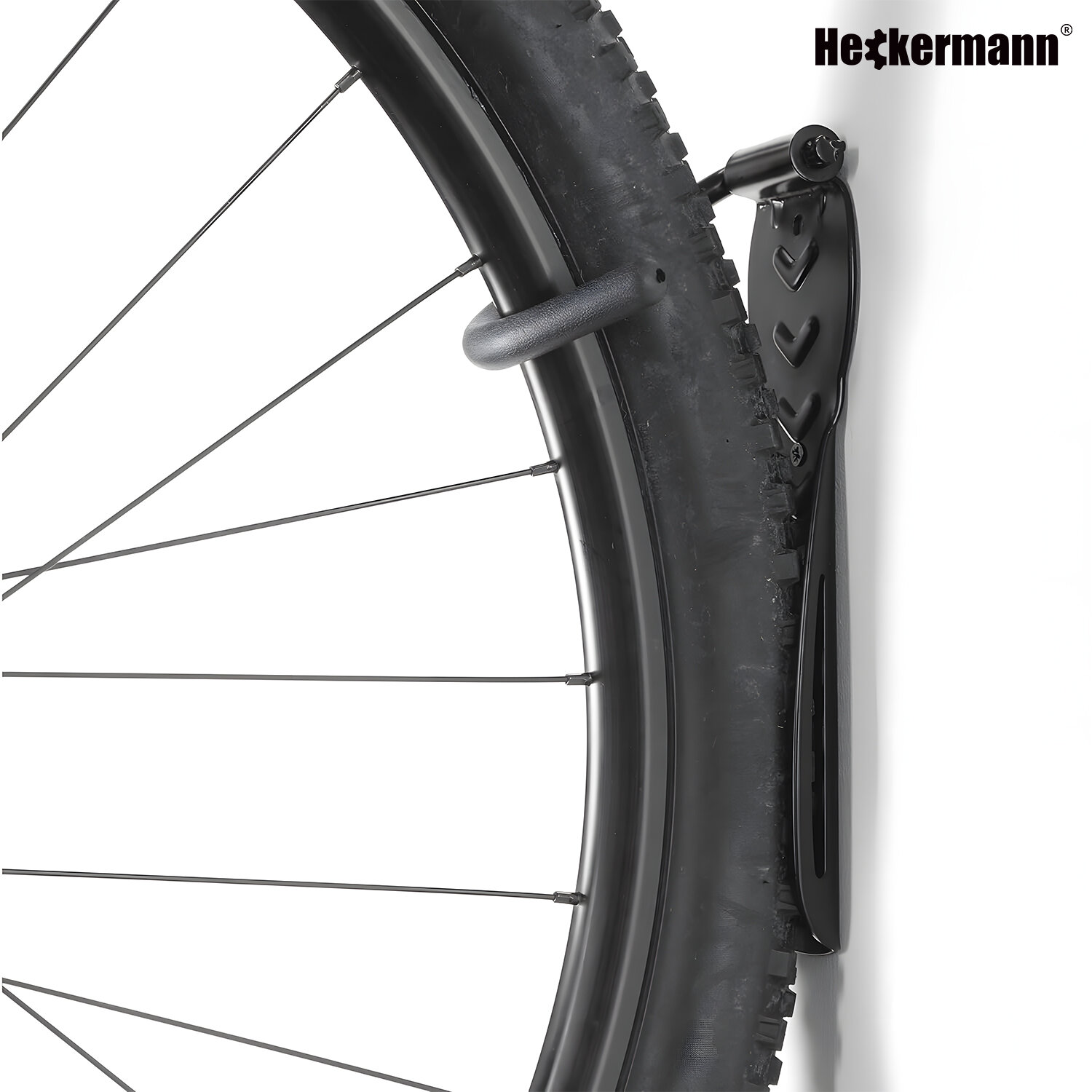 Czarny uchwyt ścienny na rower zamontowany na białej ścianie, trzymający koło roweru. W prawym górnym rogu widoczne jest logo \'Heckermann\'.
