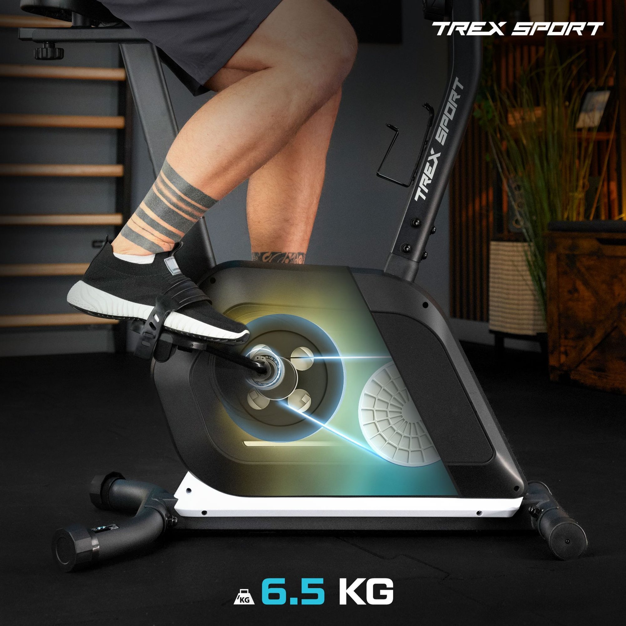 Osoba pedałuje na czarnym rowerze stacjonarnym z widocznym napisem \'TREX SPORT\'. Na obrazie znajduje się również napis \'6.5 KG\'.