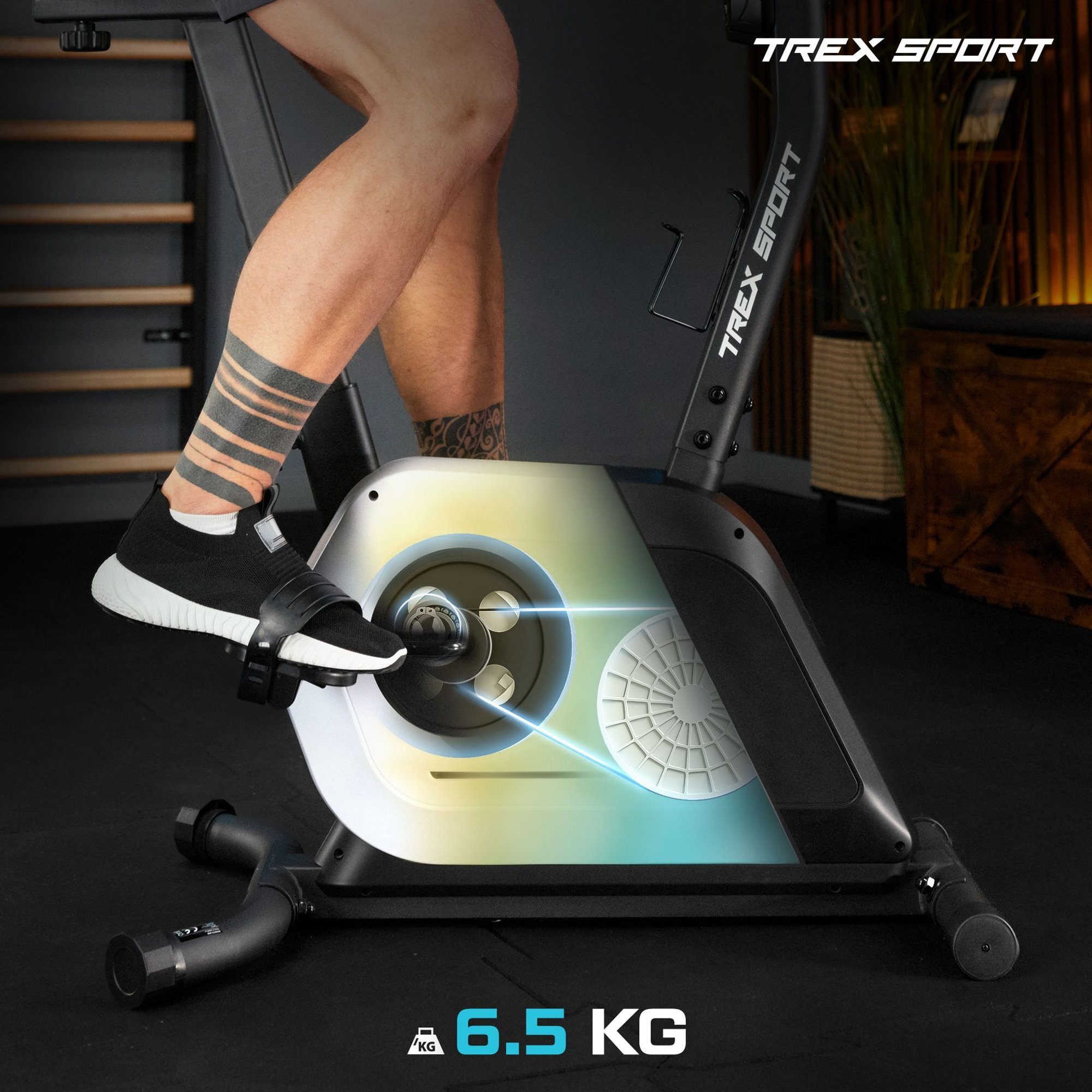 Osoba pedałuje na rowerze stacjonarnym z widocznym napisem \'TREX SPORT\'. Na dole obrazu znajduje się napis \'6.5 KG\'.