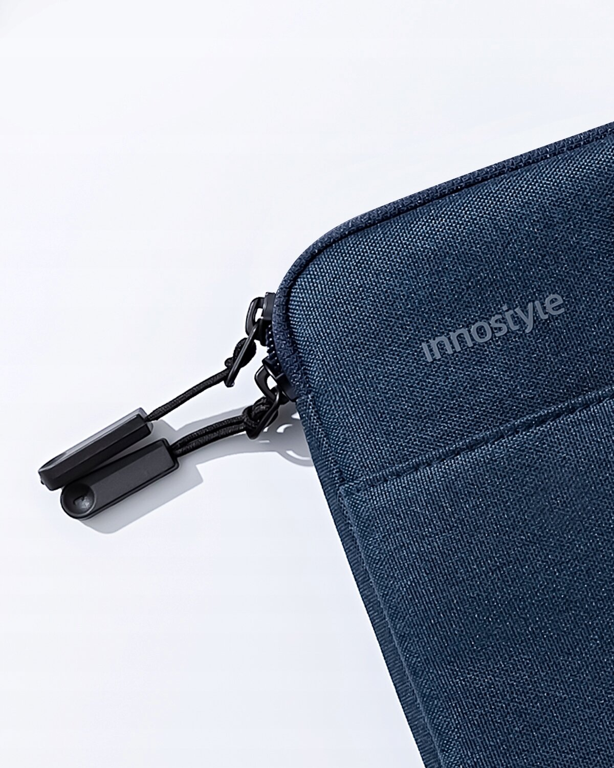 Niebieska torba na laptopa z widocznym logo \'innostyle\' i czarnym zamkiem błyskawicznym z dwoma uchwytami. Materiał wygląda na tekstylny i wodoodporny.