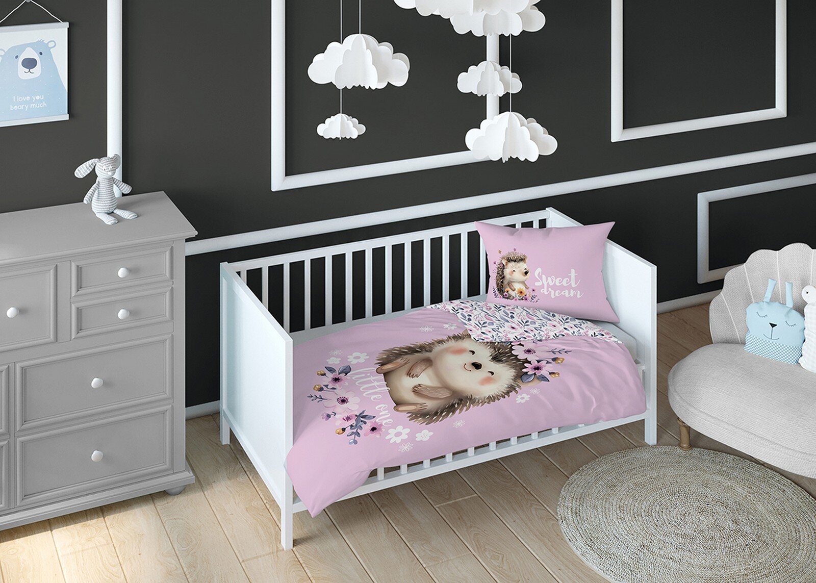 Pokój dziecięcy z białym łóżeczkiem, w którym znajduje się pościel z motywem jeża na różowym tle. Na poduszce widoczny jest napis \'Sweet dream\'.